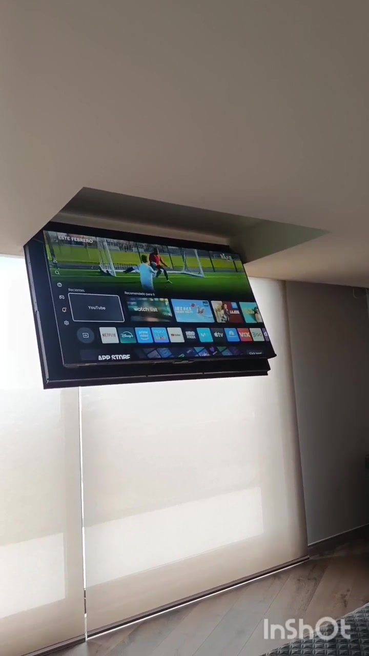 Ascensor de TV en nicho de techo junto a ventanal con persiana